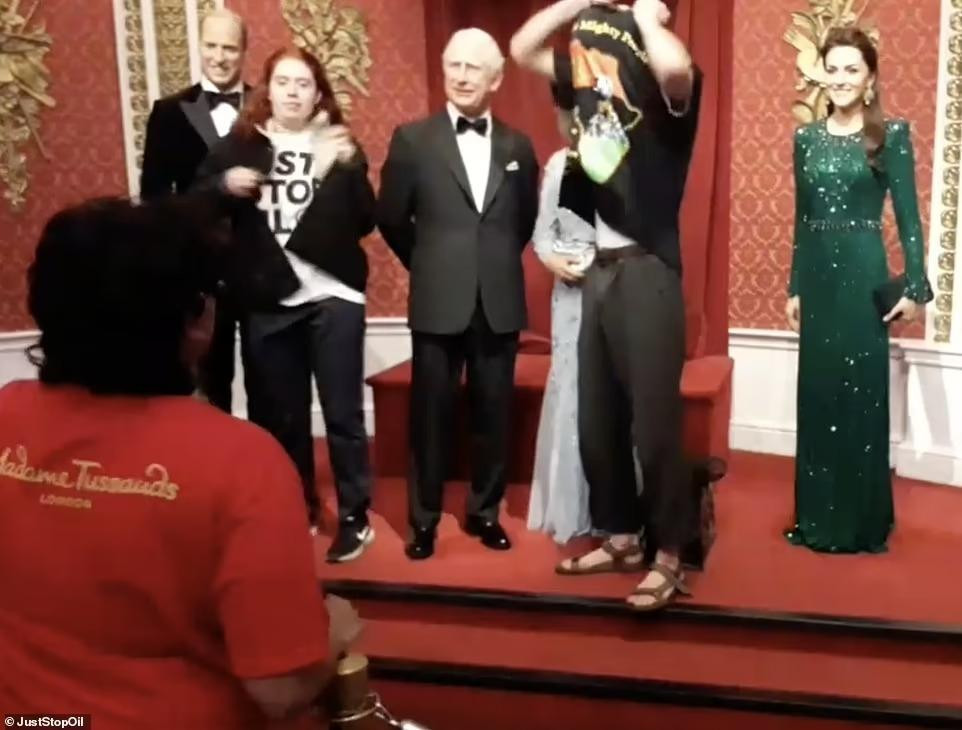 McFadden và Johnson mặc áo đen che giấu thân phận để tiếp cận tượng sáp của gia đình Hoàng gia Anh. Ảnh: Daily Mail.