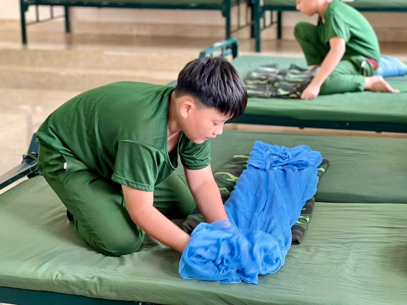 Các bạn trẻ hào hứng thực hiện gấp chăn, mền.