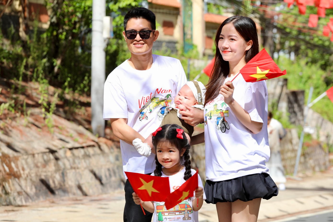 Không chỉ thu hút giới trẻ, nhiều gia đình trẻ cũng check-in trên những con đường rực rỡ sắc cờ Tổ quốc.