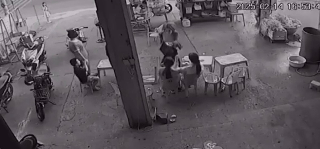 Người phụ nữ dùng chân đá vào mặt một em nhỏ.