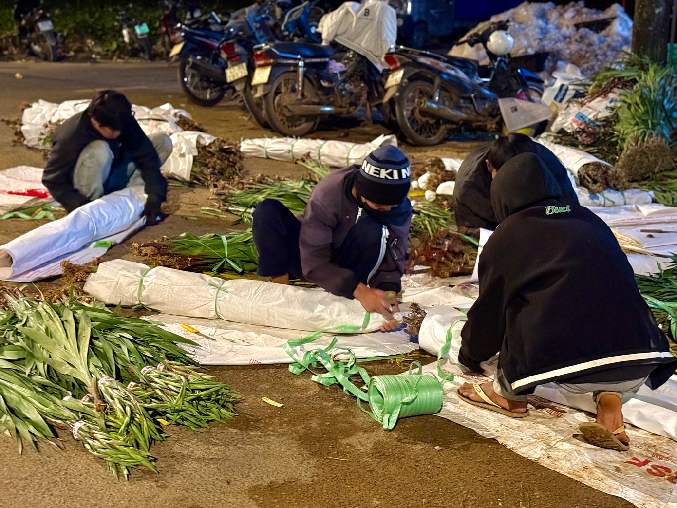 Đa số người lao động tại các điểm thu mua đều mặc nhiều áo, đội mũ... do đêm rét. Ảnh: Thái Lâm.