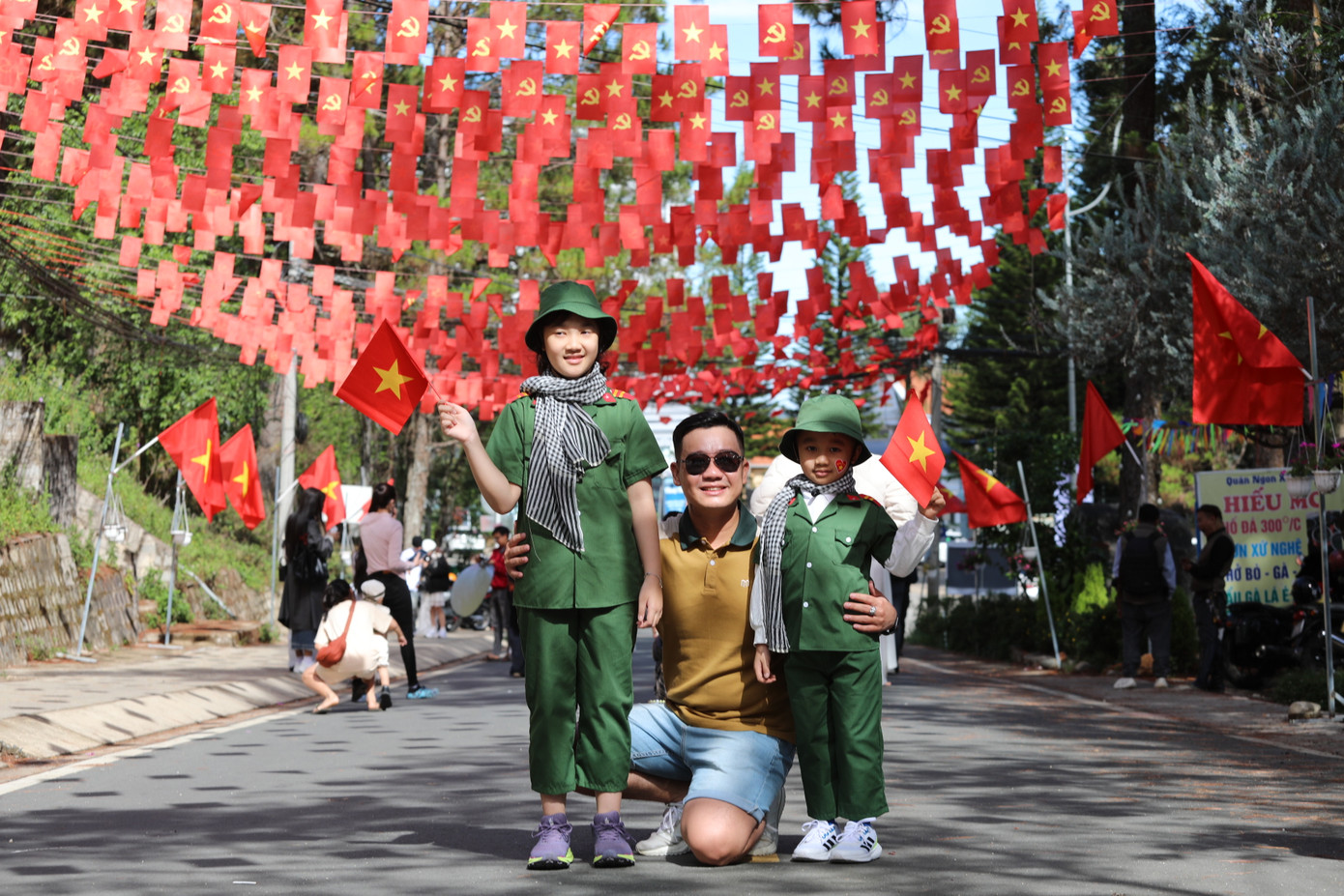 Các em bé với chiếc mũ và áo quân nhân nhỏ xinh, tay cầm cờ đỏ sao vàng, tạo nên hình ảnh vô cùng dễ thương.