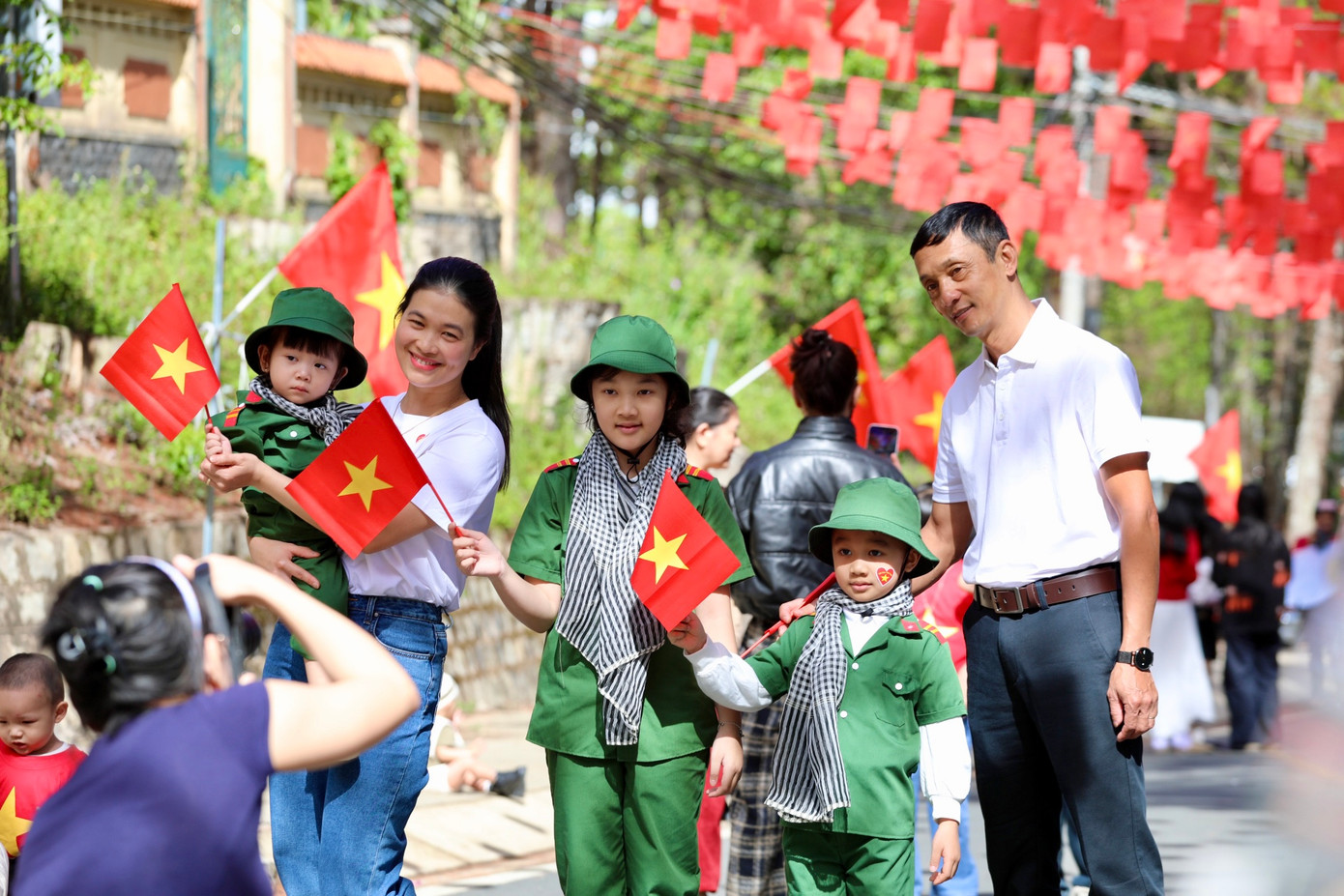Không chỉ thu hút giới trẻ, nhiều gia đình trẻ cũng check-in trên những con đường rực rỡ sắc cờ Tổ quốc.