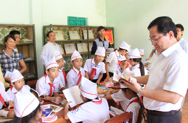 Thấy các cháu vui vẻ đọc truyện, Tổng biên tập báo Tiền Phong Lê Xuân Sơn đùa “Cho bác mượn cuốn Cái Tết của mèo con. Ngày xưa bác cũng thích đọc cuốn này lắm”. Ảnh: Trường Phong