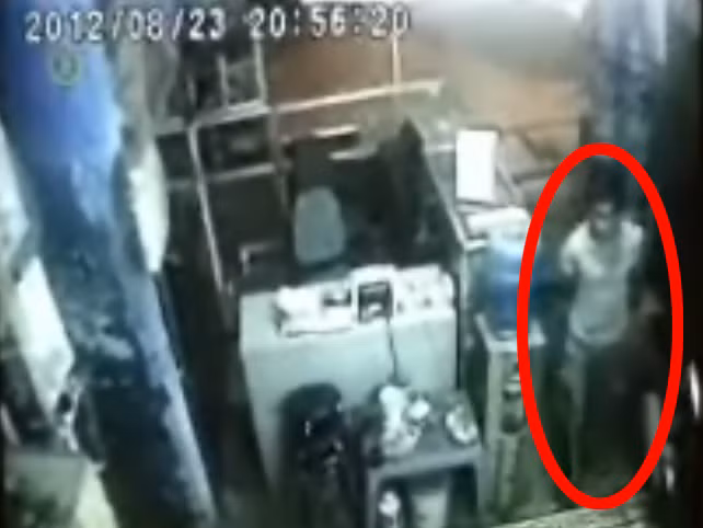 Hình ảnh camera cửa hàng ghi lại thời điểm đối tượng Trung giấu gạch sau lưng bước vào cửa hàng