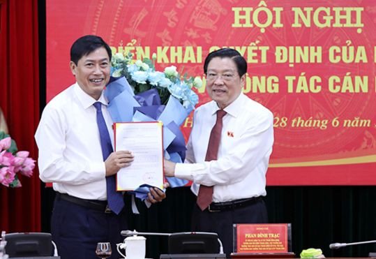 Trưởng Ban Nội chính Trung ương Phan Đình Trạc trao quyết định và tặng hoa chúc mừng Phó trưởng Ban Nội chính Trung ương Nguyễn Hữu Đông. Ảnh: Noichinh.vn.