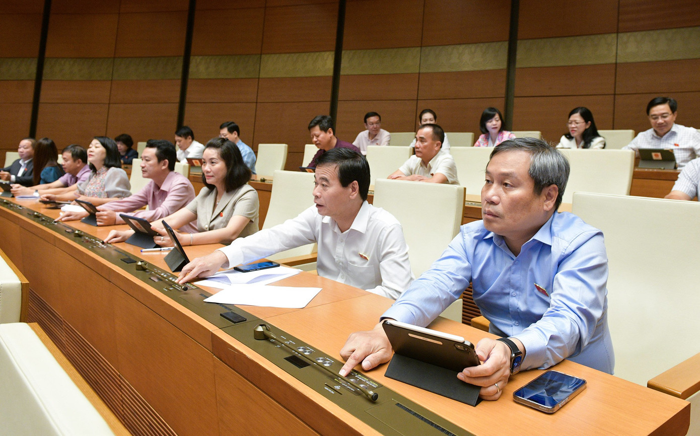 Các đại biểu Quốc hội biểu quyết thông qua dự án. Ảnh Như Ý