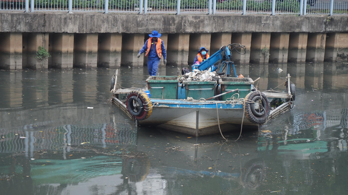 Công nhân hì hục vớt cá chết dưới kênh.
