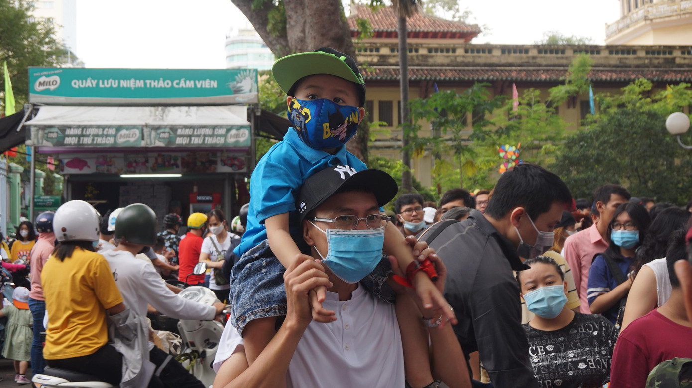 Một em nhỏ được người thân đưa đi chơi.