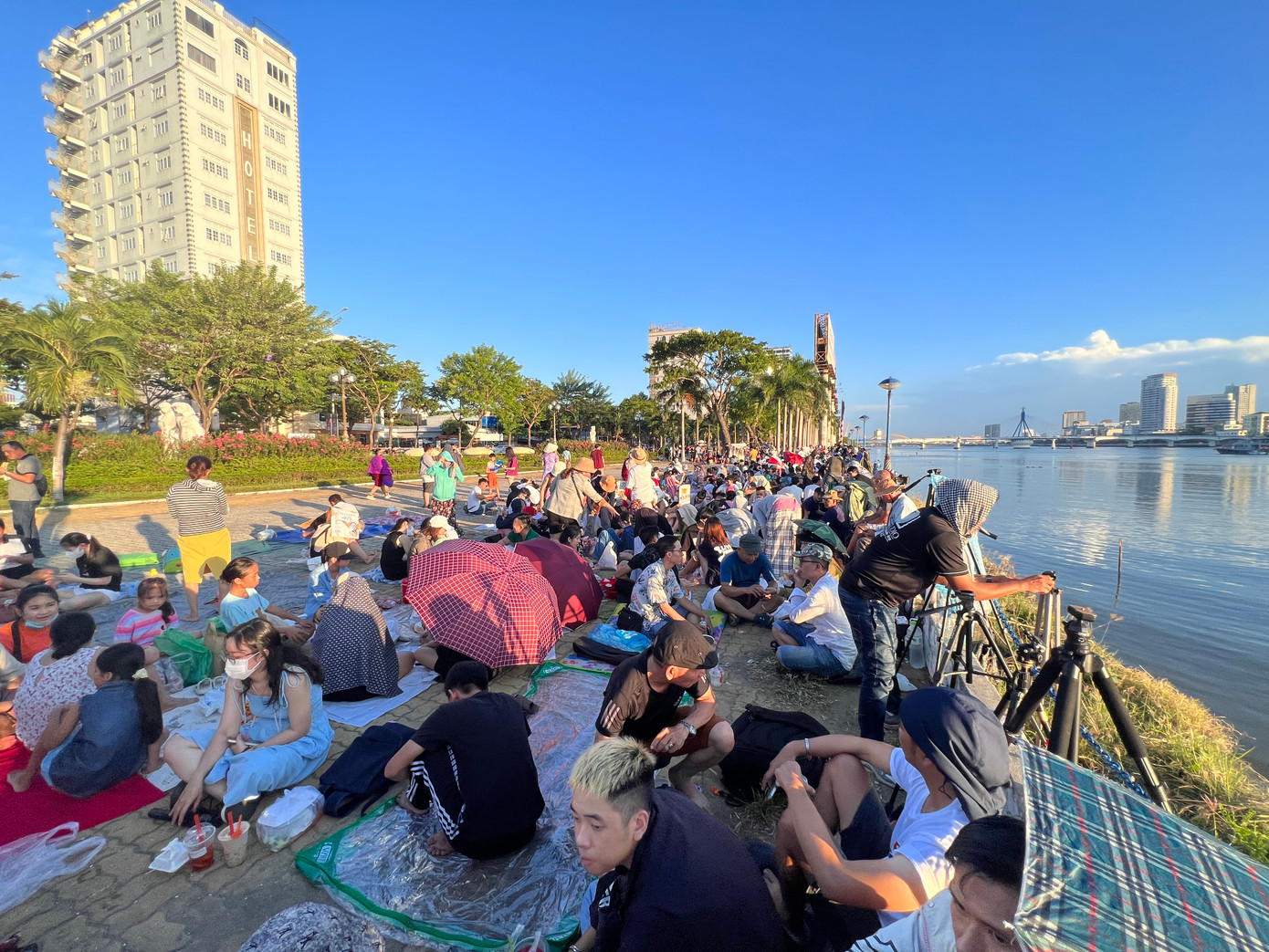 Ghi nhận của PV, từ khoảng 17h ngày 8/7, dọc hai bờ sông Hàn đã có hàng nghìn người dân, du khách trải bạt, áo mưa để giữ chỗ ngồi nơi có view đẹp. Ảnh: Thái Lâm. Ghi nhận của PV, từ khoảng 17h ngày 8/7, dọc hai bờ sông Hàn đã có hàng nghìn người dân, du khách trải bạt, áo mưa để giữ chỗ ngồi nơi có view đẹp. Ảnh: Thái Lâm.