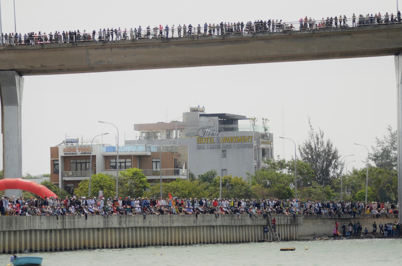 Hàng nghìn người dân, du khách đã tập trung ở dưới chân cầu và trên cầu Thuận Phước để theo dõi, cổ vũ các đội thi. Chị Lê Thị Vân (trú huyện Duy Xuyên, tỉnh Quảng Nam) chia sẻ: "Từ sớm, tôi và đội cổ vũ đã thuê xe ô tô 16 chỗ ra Đà Nẵng. Mong đội mình giành chiến thắng và chiêm ngưỡng giải đấu thật hấp dẫn". Ảnh: Thái Lâm.