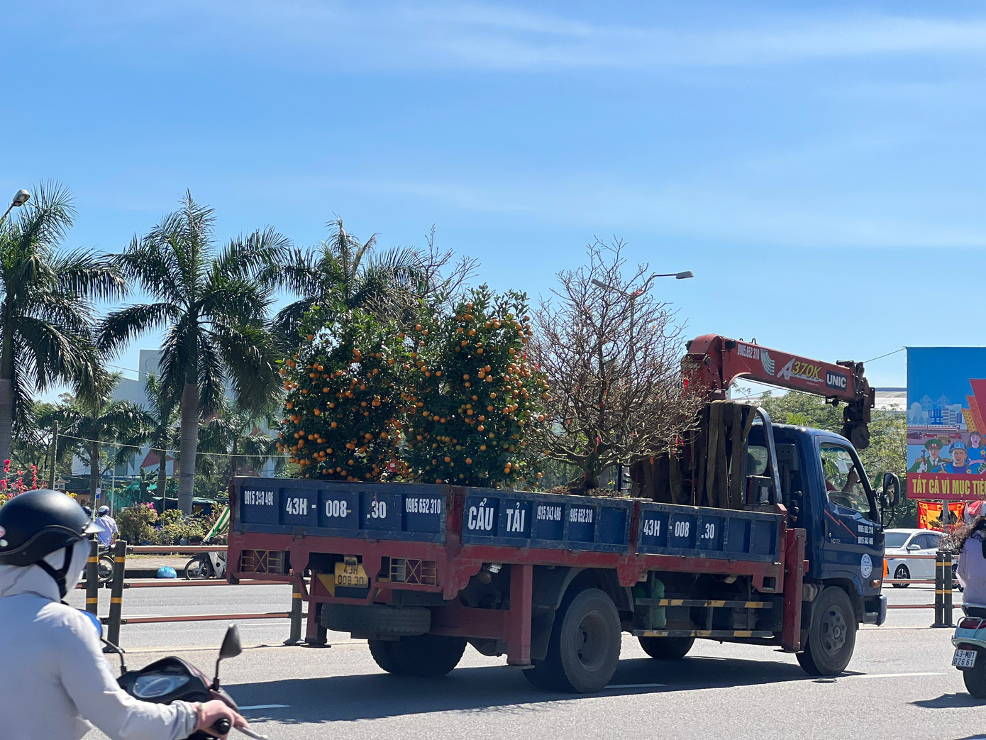 Hoa Tết "đổ bộ" về các chợ hoa, dịch vụ vận chuyển liên tục chạy sô kiếm tiền khiến đường phố nhộn nhịp hơn.