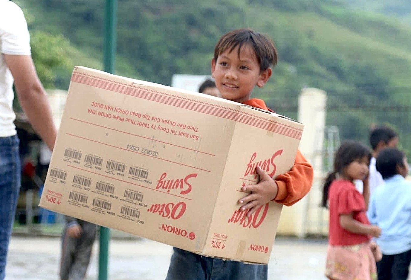 Các em học sinh vui mừng phấn khởi bưng quà của mình về lớp.