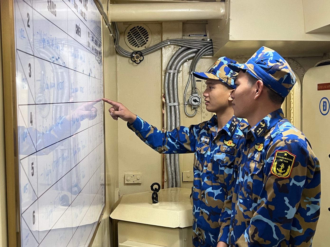 Thiếu úy chuyên nghiệp Nguyễn Trọng Tuấn (SN 1996, quê Nghệ An) cùng đồng đội xem lịch phân công nhiệm vụ. Ảnh: Thái Lâm. Thiếu úy chuyên nghiệp Nguyễn Trọng Tuấn (SN 1996, quê Nghệ An) cùng đồng đội xem lịch phân công nhiệm vụ. Ảnh: Thái Lâm.