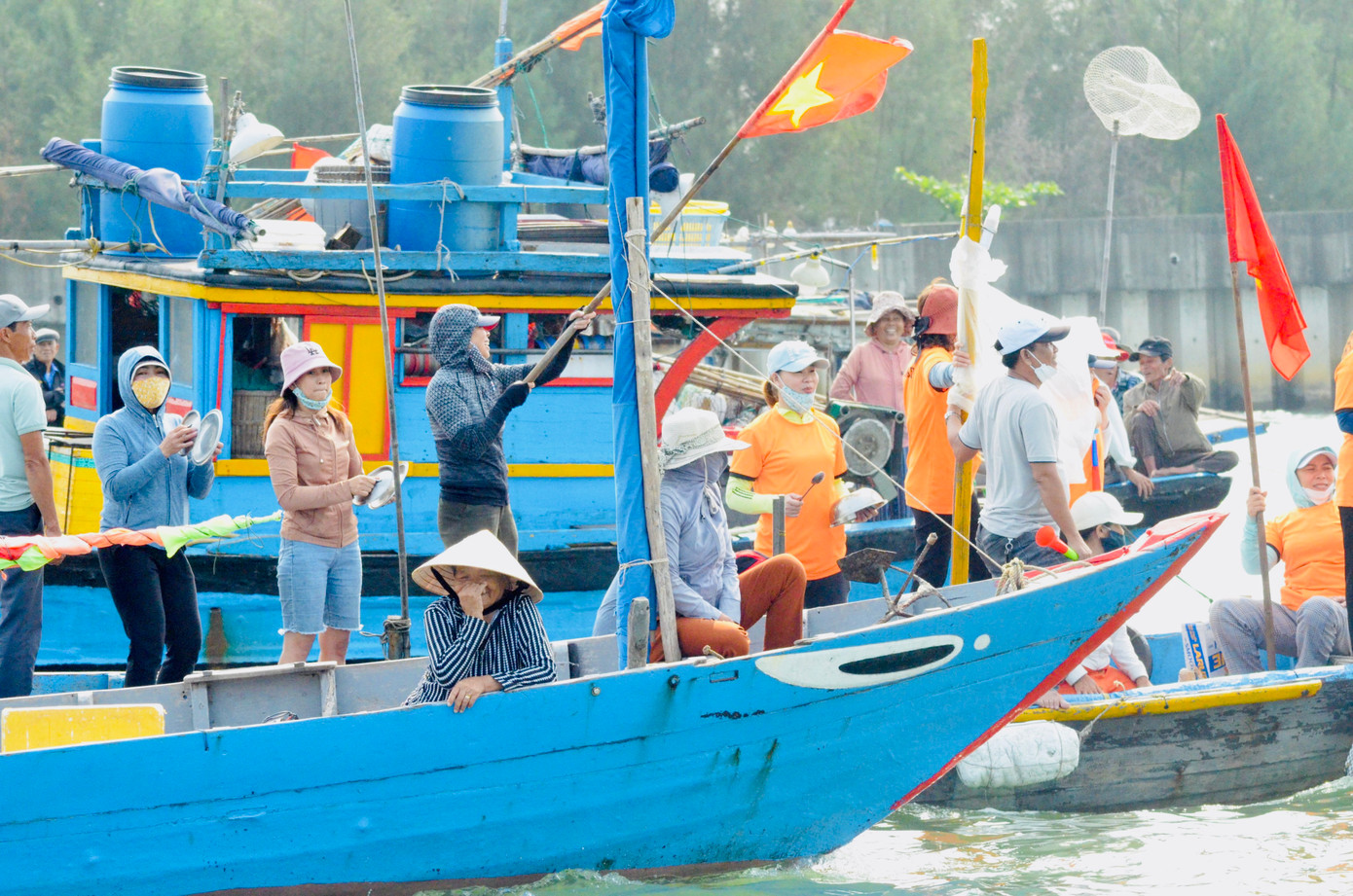 Xoong nồi, xô chậu, cờ tổ quốc là vật dụng các cổ động viên dùng để cổ vũ trong giải đua thuyền truyền thống sôi động của ngư dân Phường Nại Hiên Đông (quận Sơn Trà, TP Đà Nẵng) sáng nay. Ảnh: Thái Lâm.