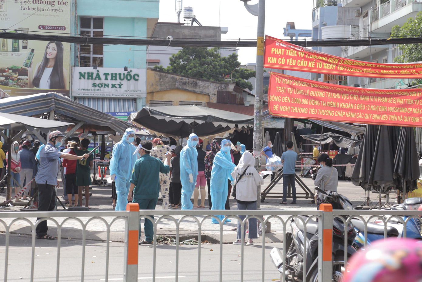 Nhân viên y tế hướng dẫn người dân, tiểu thương đảm bảo khoảng cách khi lấy mẫu xét nghiệm.
