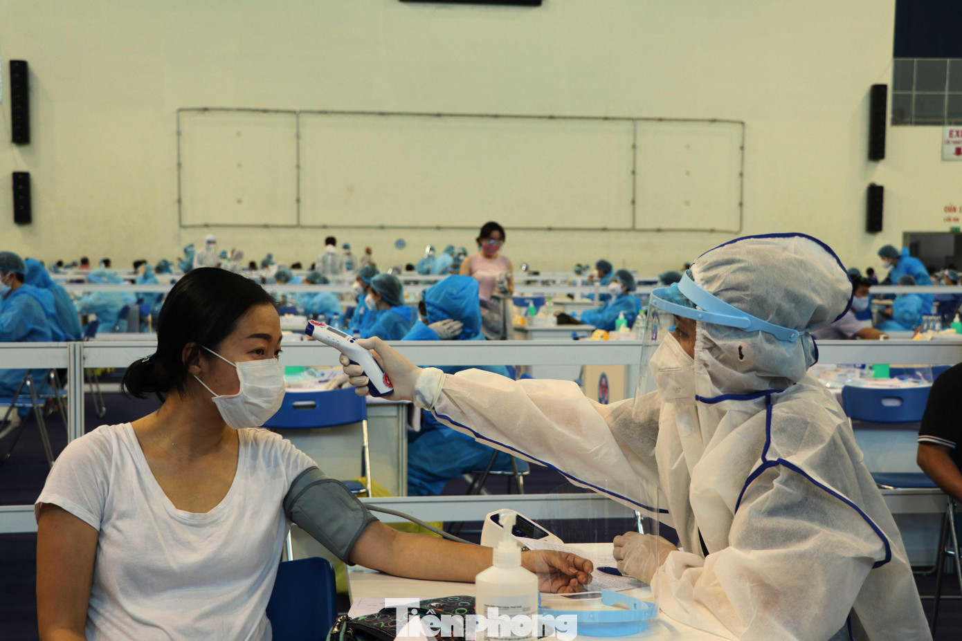 Nhân viên y tế kiểm tra kỹ thân nhiệt, huyết áp, nhịp tim của người dân trước khi chỉ định tiêm vắc xin ngừa COVID-19.