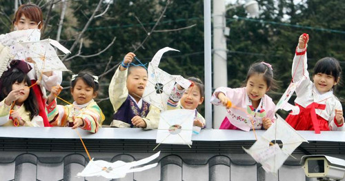 Các em bé thành phố Busan, Hàn Quốc thả diều trên một cây cầu trước khi bước sang năm mới. Ảnh: Chosun