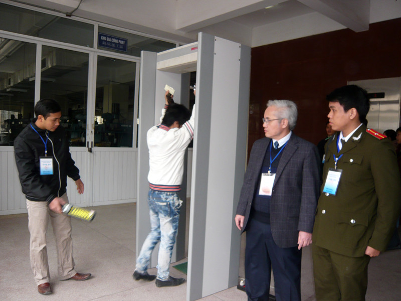 Ông Phan Văn Minh-Giám đốc Trung tâm lao động ngoài nước và cán bộ Phòng A83 Công an Hà Nội chỉ đạo kiểm tra thí sinh dùng điện thoại tại các cổng từ