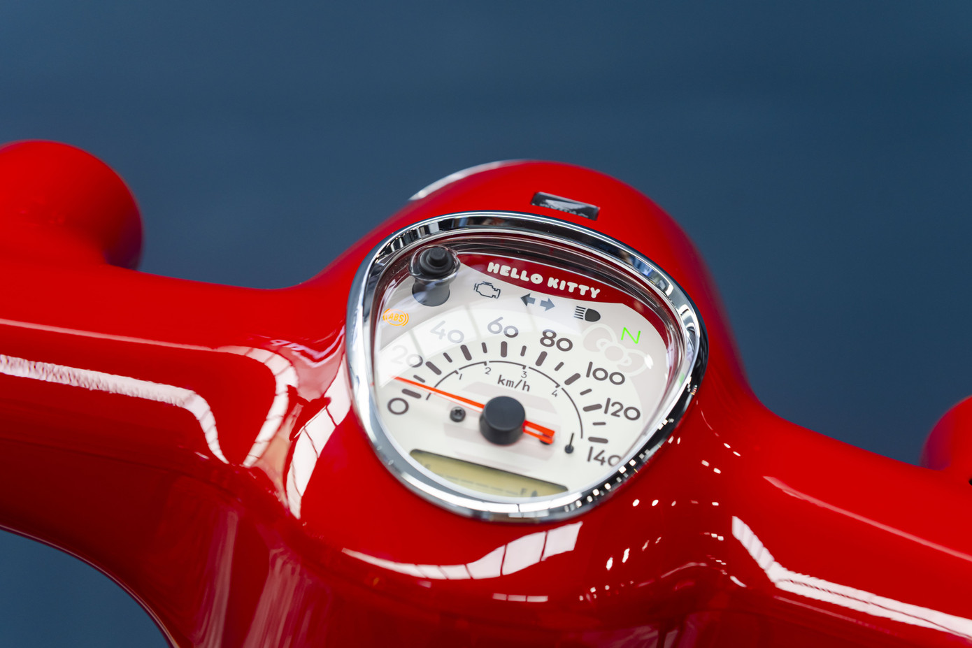 Honda Super Cub Hello Kitty sở hữu phối màu đỏ và be. Logo mèo Hello Kitty xuất hiện trên nhiều vị trí như ốp hông, yếm xe phía trước, bọc yên bằng da, chìa khóa cơ, đồng hồ tốc độ dạng analog kết hợp màn hình kỹ thuật số.