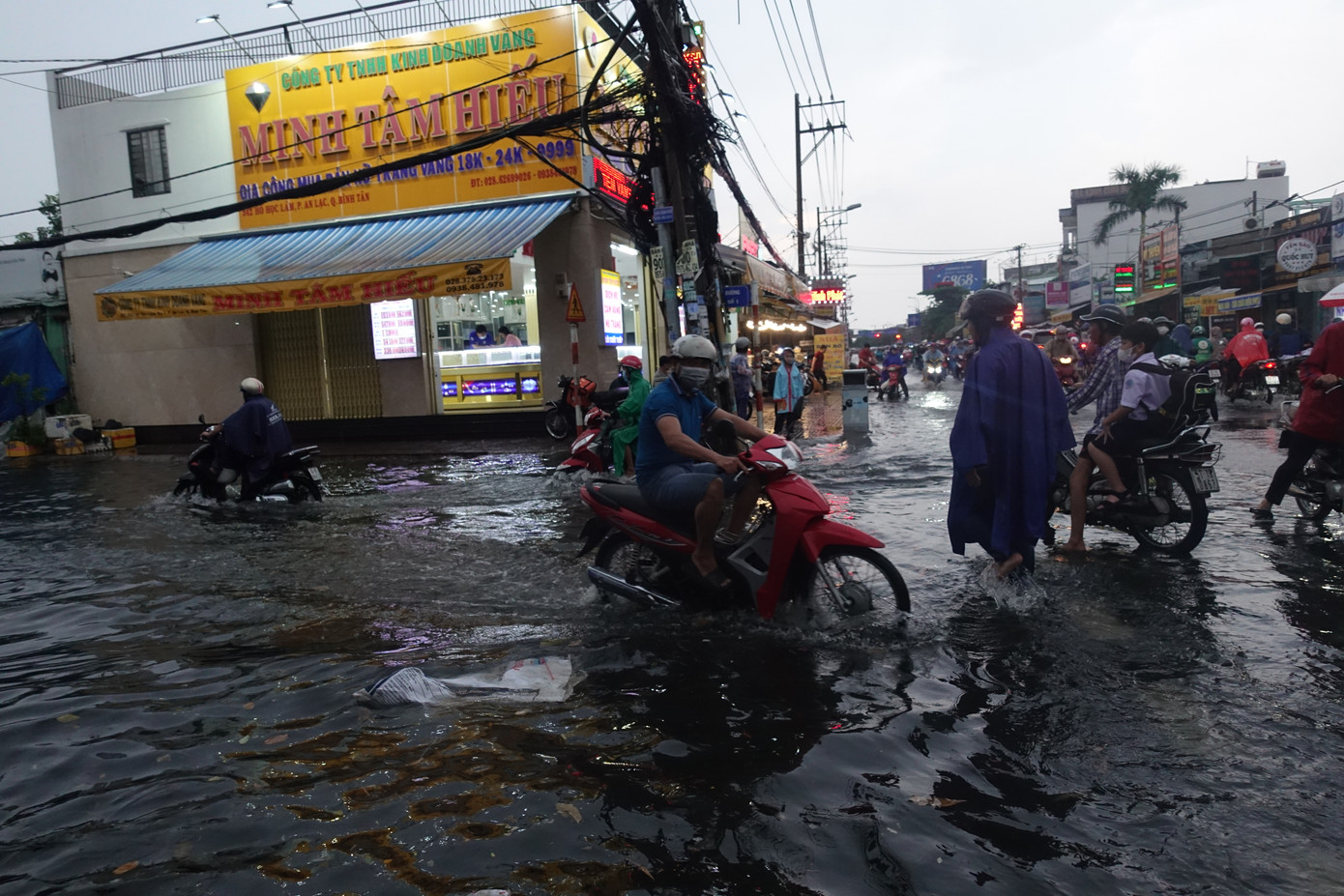 Người dân bì bõm trên đường sau cơn mưa.