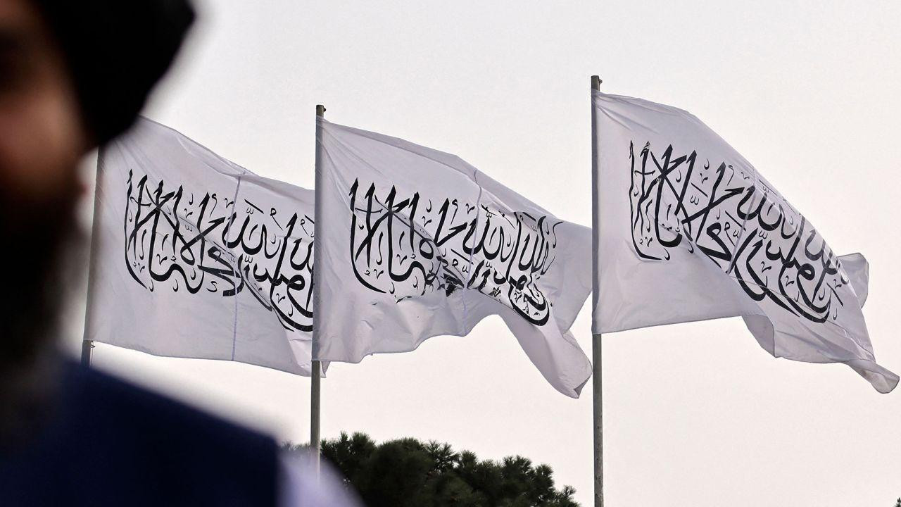 Một chiến binh Taliban được chụp trên nền cờ Taliban được cắm tại sân bay quốc tế Hamid Karzai ở thủ đô Kabul của Afghanistan ngày 11/9/2021. Ảnh: Getty Images. Một chiến binh Taliban được chụp trên nền cờ Taliban được cắm tại sân bay quốc tế Hamid Karzai ở thủ đô Kabul của Afghanistan ngày 11/9/2021. Ảnh: Getty Images.