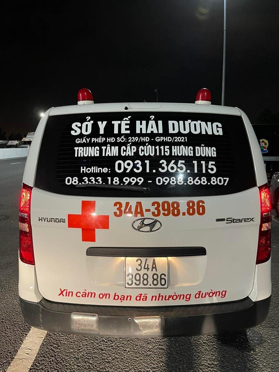 Chiếc xe cứu thương chở nhóm người qua chốt kiểm dịch.