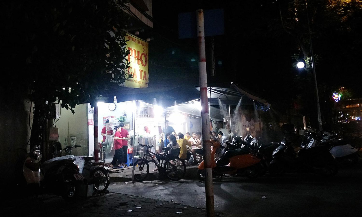Một quán phở biến vỉa hè thành nơi ăn uống, lòng đường làm chỗ để xe máy của khách. Một quán phở biến vỉa hè thành nơi ăn uống, lòng đường làm chỗ để xe máy của khách.