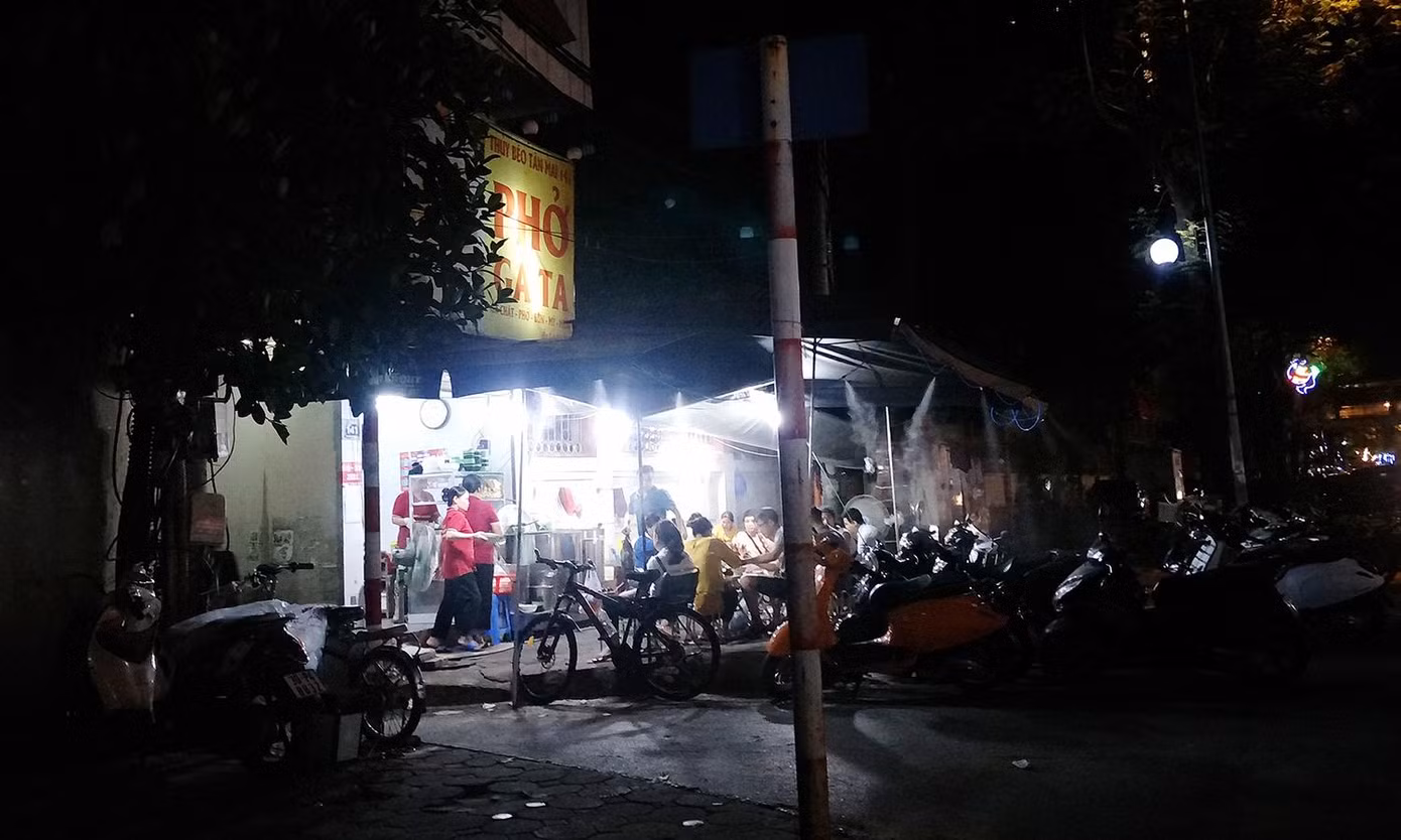 Một quán phở biến vỉa hè thành nơi ăn uống, lòng đường làm chỗ để xe máy của khách. Một quán phở biến vỉa hè thành nơi ăn uống, lòng đường làm chỗ để xe máy của khách.