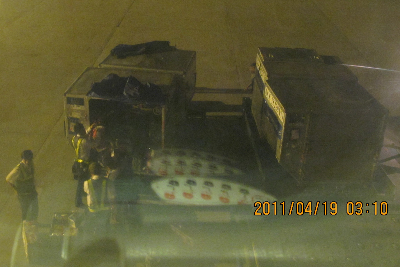 Ảnh chụp qua cửa sổ máy bay cảnh dỡ hành lý cho nhóm ông Khương rời máy bay