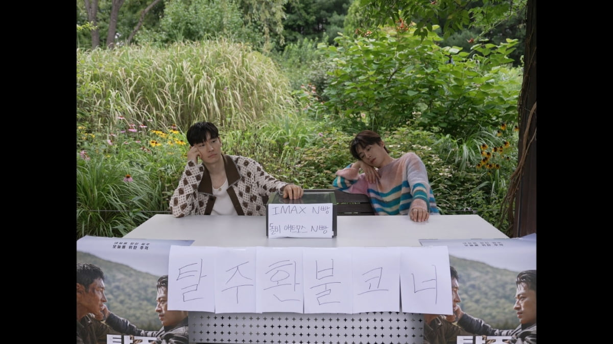 Các diễn viên Lee Je Hoon và Koo Kyo Hwan đang thu hút sự chú ý bằng cách tạo ra một góc hoàn tiền cho bộ phim Escape. Trong một video phát hành vào ngày 10/8, Lee Je Hoon và Koo Kyo Hwan đã thiết lập một 'Escape hoàn tiền' ở lối vào rừng Seoul ở Seongdong Gu, Seoul. Trước đây, Lee Je Hoon đã xuất hiện trên Salon Drip 2 và cam kết: "Nếu bạn không thích bộ phim sau khi xem nó, tôi sẽ hoàn lại tiền cho bạn ngay trước mặt rừng Seoul". Koo Kyo Hwan tiếp thêm sức mạnh cho lời cam kết khi nói: “Tôi sẽ làm bánh mì N”. Trong buổi chào sân khấu vào tuần đầu tiên ra mắt, hai diễn viên đã nói về việc 'hãy tạo một góc hoàn tiền cho Escape tại rừng Seoul', và quay video ngay ngày hôm trước màn chào sân bắt đầu. Việc chỉ đạo, biên tập và viết chữ đều do Koo Kyo Hwan đảm nhận. Trong video, cả hai đã bày một chiếc bàn ở lối vào rừng Seoul và treo một tấm biển lớn ghi 'Góc hoàn tiền Escape '. Trên bàn, một hộp tiền chứa tiền mặt có dòng chữ 'IMAX N Bread' và 'Dolby Atmos N Bread' viết trên đó số tiền hoàn lại được dùng làm chỗ dựa, khiến mọi người bật cười. Lee Je Hoon và Koo Kyo Hwan chờ đợi khán giả không ngừng nghỉ nhưng khi không có ai yêu cầu hoàn tiền, hai diễn viên trở nên chán nản và bỏ đi, đó cũng là một điểm thú vị khác trong video. Các diễn viên Lee Je Hoon và Koo Kyo Hwan đang thu hút sự chú ý bằng cách tạo ra một góc hoàn tiền cho bộ phim Escape. Trong một video phát hành vào ngày 10/8, Lee Je Hoon và Koo Kyo Hwan đã thiết lập một 'Escape hoàn tiền' ở lối vào rừng Seoul ở Seongdong Gu, Seoul. Trước đây, Lee Je Hoon đã xuất hiện trên Salon Drip 2 và cam kết: "Nếu bạn không thích bộ phim sau khi xem nó, tôi sẽ hoàn lại tiền cho bạn ngay trước mặt rừng Seoul". Koo Kyo Hwan tiếp thêm sức mạnh cho lời cam kết khi nói: “Tôi sẽ làm bánh mì N”. Trong buổi chào sân khấu vào tuần đầu tiên ra mắt, hai diễn viên đã nói về việc 'hãy tạo một góc hoàn tiền cho Escape tại rừng Seoul', và quay video ngay ngày hôm trước màn chào sân bắt đầu. Việc chỉ đạo, biên tập và viết chữ đều do Koo Kyo Hwan đảm nhận. Trong video, cả hai đã bày một chiếc bàn ở lối vào rừng Seoul và treo một tấm biển lớn ghi 'Góc hoàn tiền Escape '. Trên bàn, một hộp tiền chứa tiền mặt có dòng chữ 'IMAX N Bread' và 'Dolby Atmos N Bread' viết trên đó số tiền hoàn lại được dùng làm chỗ dựa, khiến mọi người bật cười. Lee Je Hoon và Koo Kyo Hwan chờ đợi khán giả không ngừng nghỉ nhưng khi không có ai yêu cầu hoàn tiền, hai diễn viên trở nên chán nản và bỏ đi, đó cũng là một điểm thú vị khác trong video.