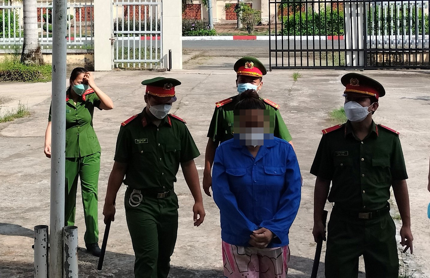 T. được lực lượng công an dẫn giải đến phiên toà.