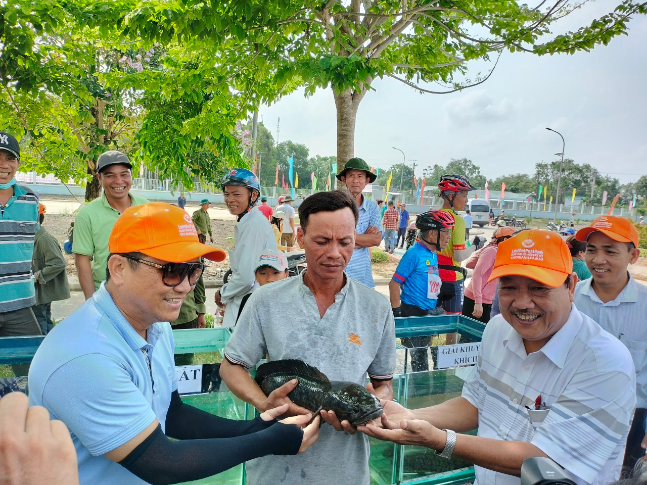 Chủ nhân "cá lóc to nhất" chụp ảnh cùng Ban tổ chức cuộc thi. Ảnh: Tân Lộc.