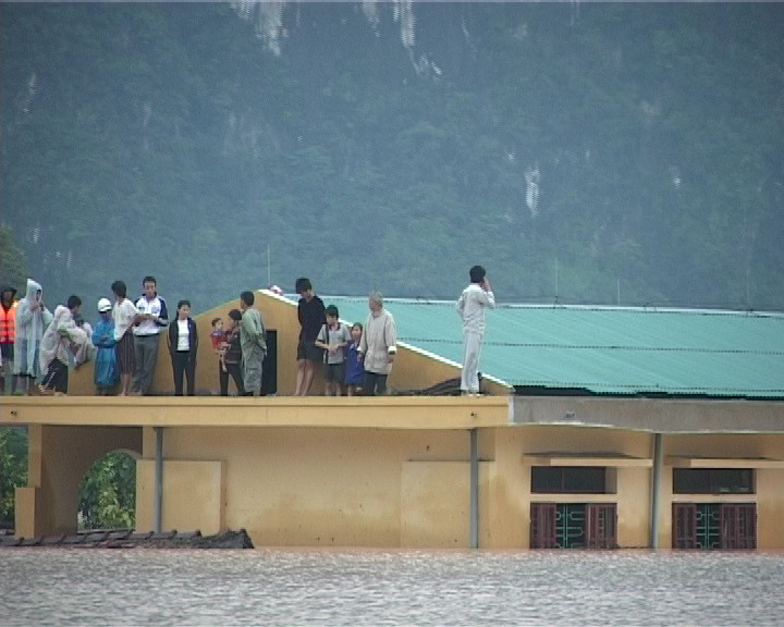 Người dân phải sống trên mái nhà tránh lũ. Ảnh: Hoàng Nam