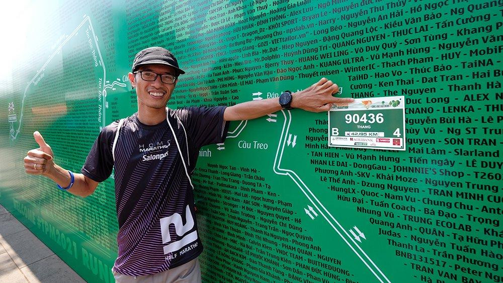 Nhiều vận động viên tìm tên mình, ghi lại khoảnh khắc kỷ niệm ở backdrop khổng lồ dựng cạnh các quầy trả racekit.