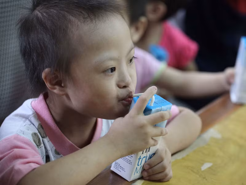 Cháu Nguyễn Thị Trang, 8 tuổi ở Trung tâm Bảo trợ Xã hội tỉnh uống sữa TH