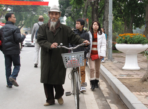 Một cụ già dắt xe dạo phố hoa