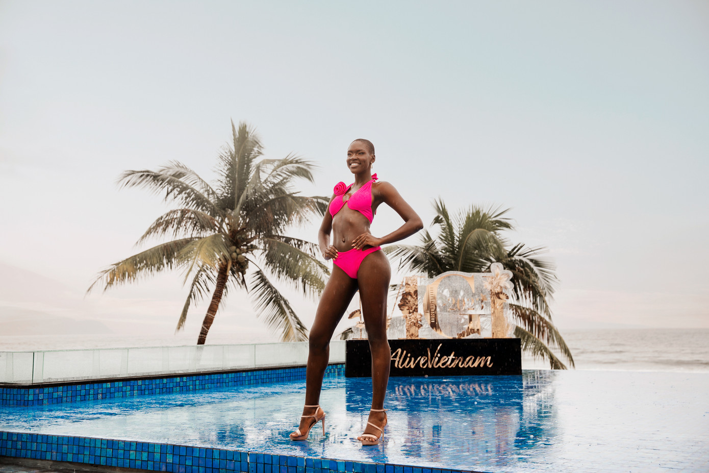 Các thí sinh bước xuống từ cầu thang và catwalk qua khu vực hồ bơi.