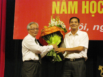 Tiến sĩ Nguyễn Tùng Lâm, hiệu trường trường THPT Đinh Tiên Hoàng (bên trái) nhận bó hoa tri ân của đại diện phụ huynh học sinh