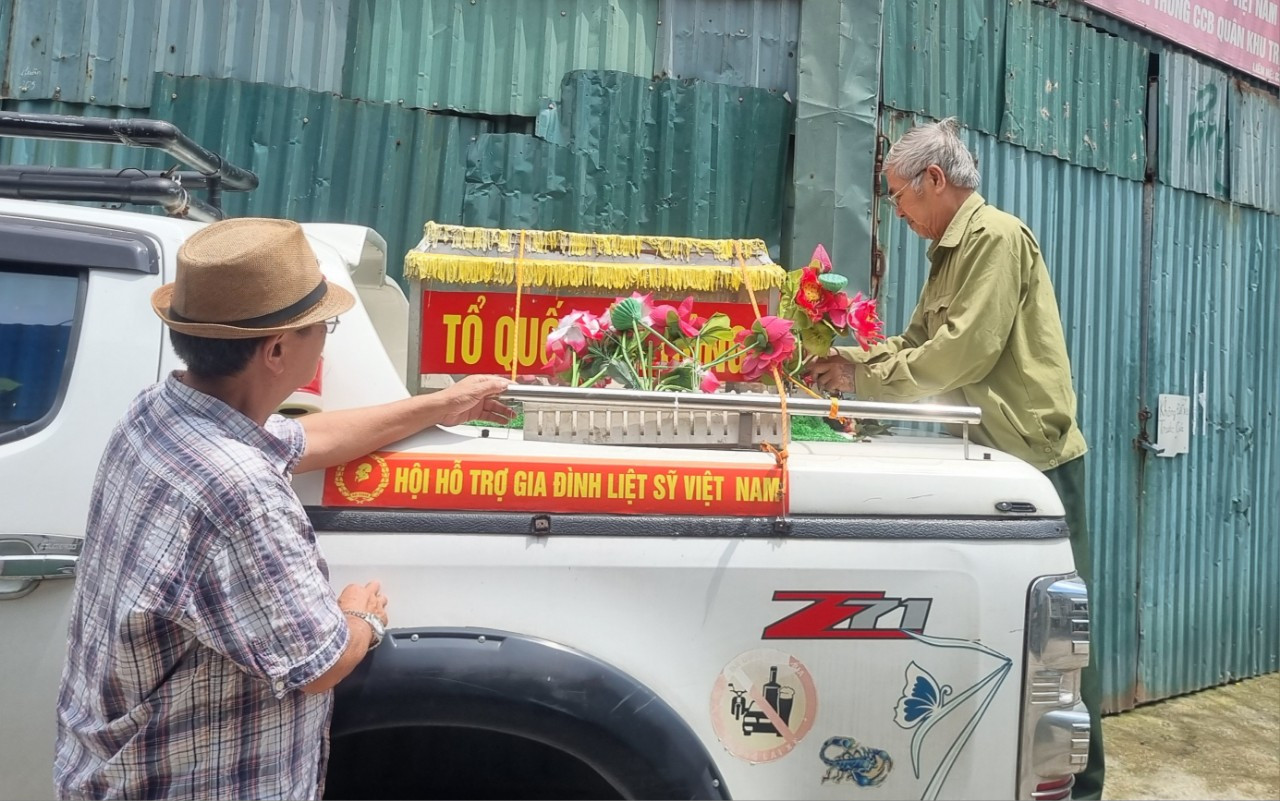 Ông Đỗ Tuấn Đạt (bên phải) kiểm tra độ chắc chắn của linh xa trên nóc xe