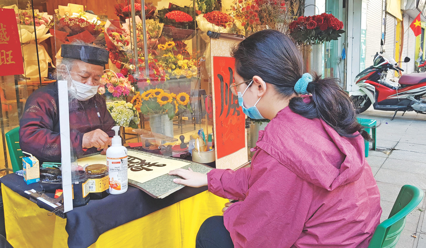 Ông đồ Vũ Ngọc Kỳ viết thư pháp cho khách du xuân tại khu vực Văn Miếu - Quốc Tử Giám Ảnh: K.N Ông đồ Vũ Ngọc Kỳ viết thư pháp cho khách du xuân tại khu vực Văn Miếu - Quốc Tử Giám Ảnh: K.N