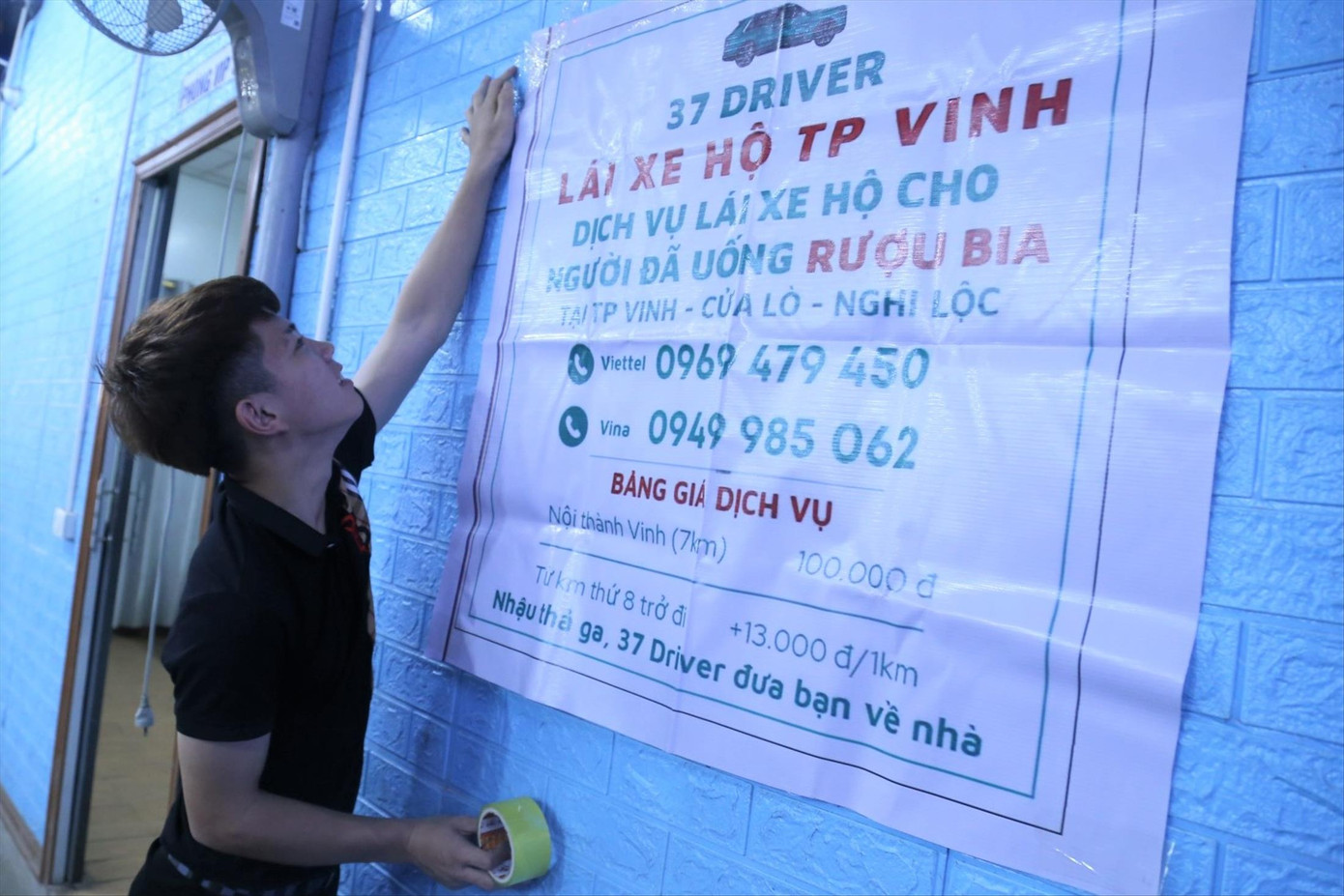 Nhân viên một nhà hàng dán biển dịch vụ lái xe hộ Nhân viên một nhà hàng dán biển dịch vụ lái xe hộ