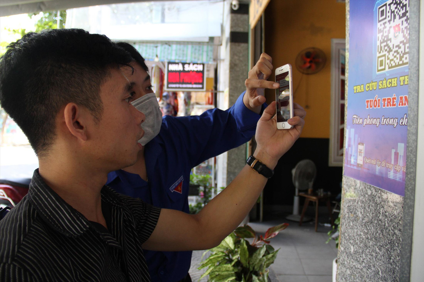 Các tình nguyện viên Đoàn phường hướng dẫn bạn trẻ quét mã và tìm sách trong thư viện Ảnh: Giang Thanh