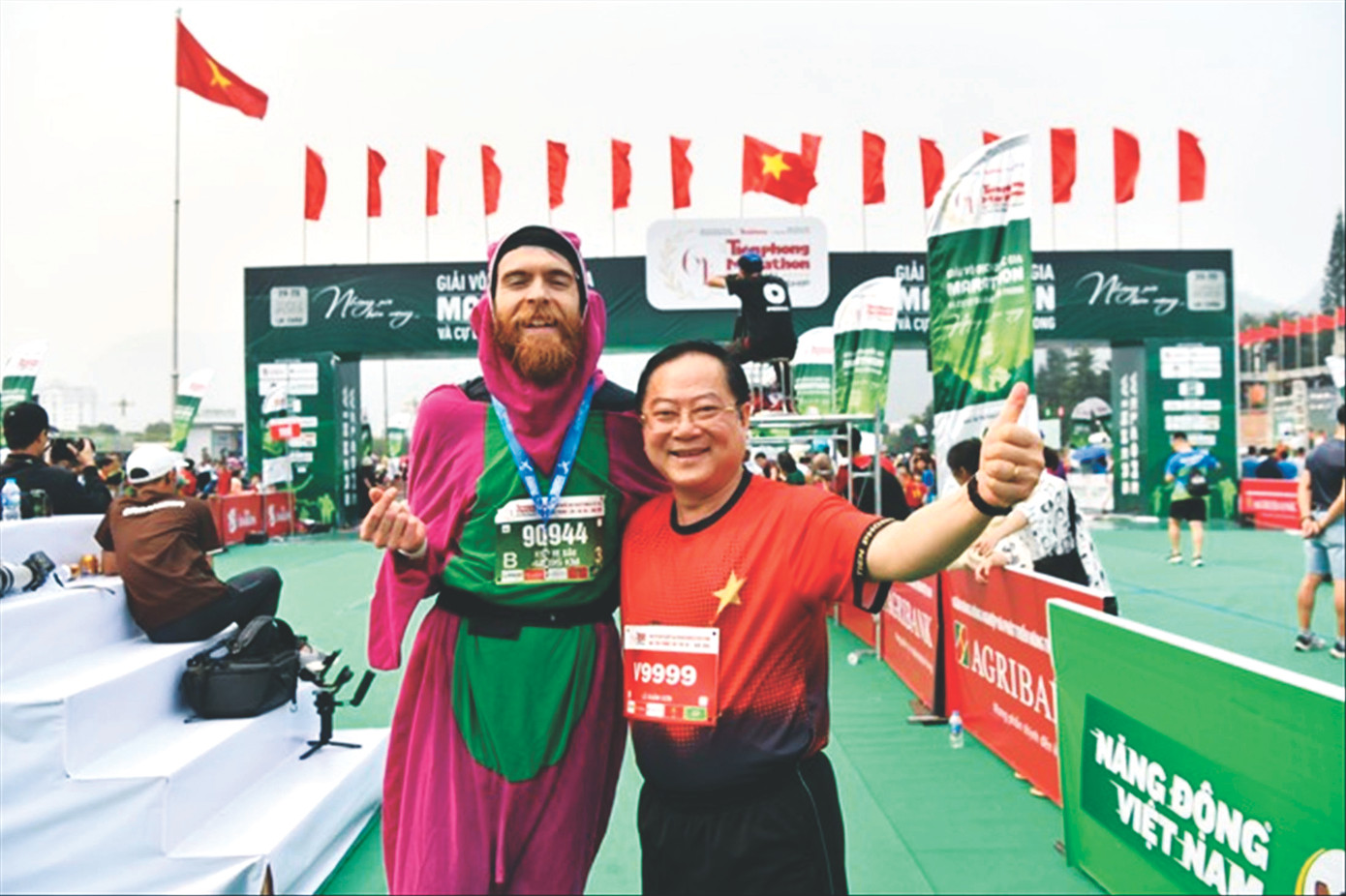 Nhà báo Lê Xuân Sơn - Tổng Biên tập báo Tiền Phong, đồng Trưởng Ban tổ chức Tiền Phong Marathon, chung vui cùng VĐV Liam Watson tại vạch đích