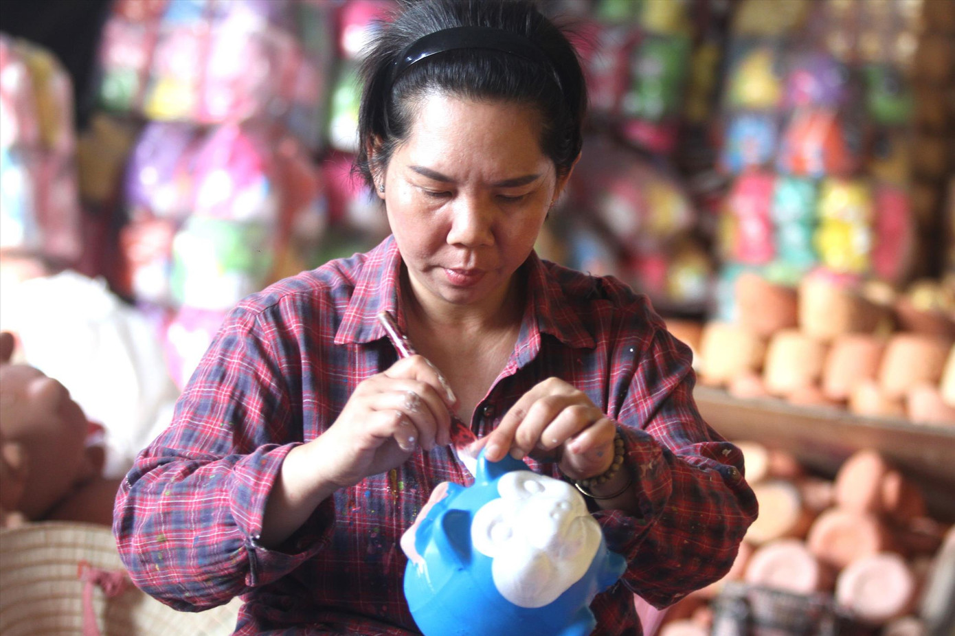 Nghệ nhân tỉ mỉ tô điểm cho heo đất ảnh: H.C Nghệ nhân tỉ mỉ tô điểm cho heo đất ảnh: H.C