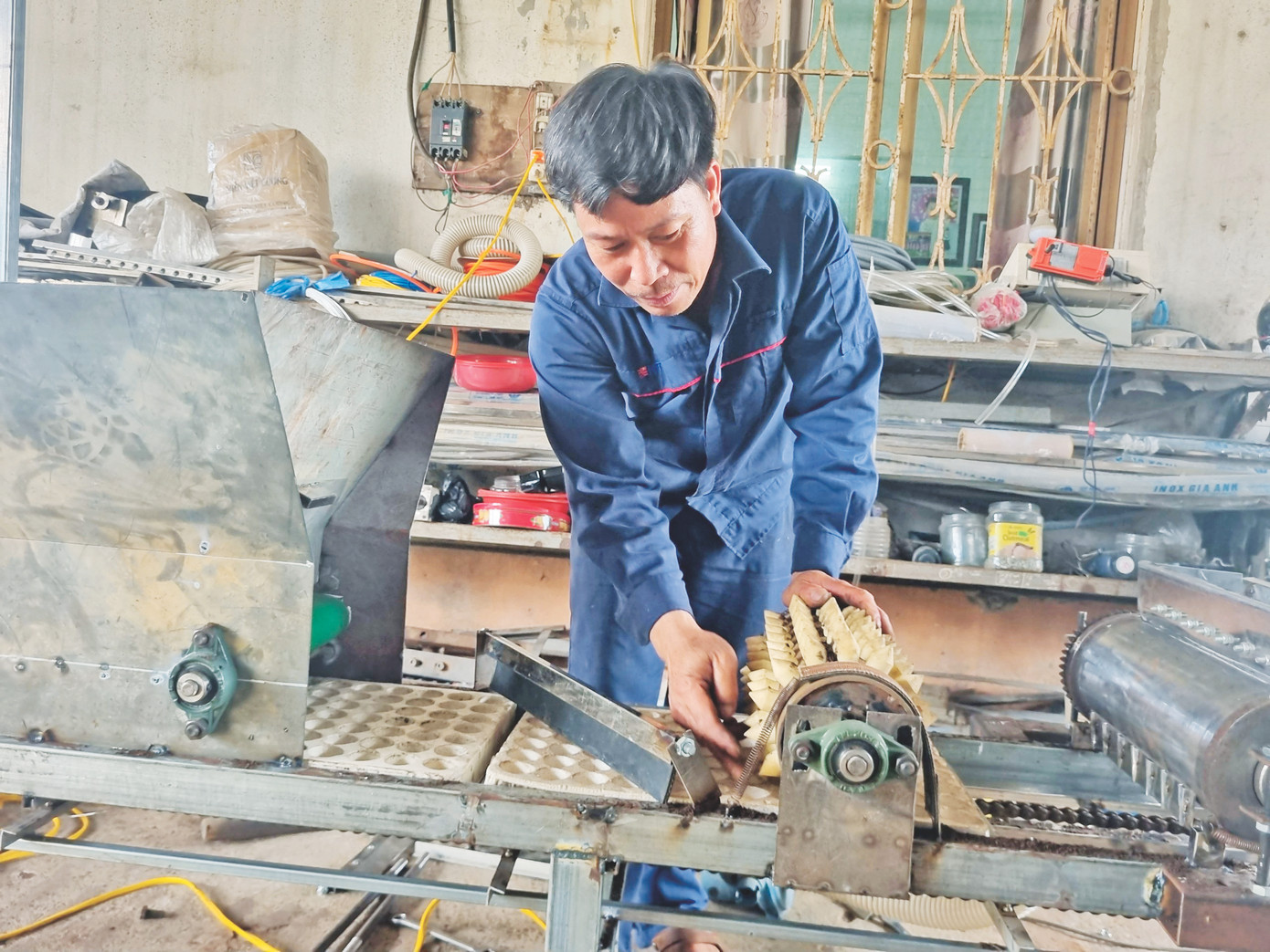 Anh Phạm Văn Hát đang hoàn thành công đoạn thử nghiệm máy đặt hạt trên khay Anh Phạm Văn Hát đang hoàn thành công đoạn thử nghiệm máy đặt hạt trên khay