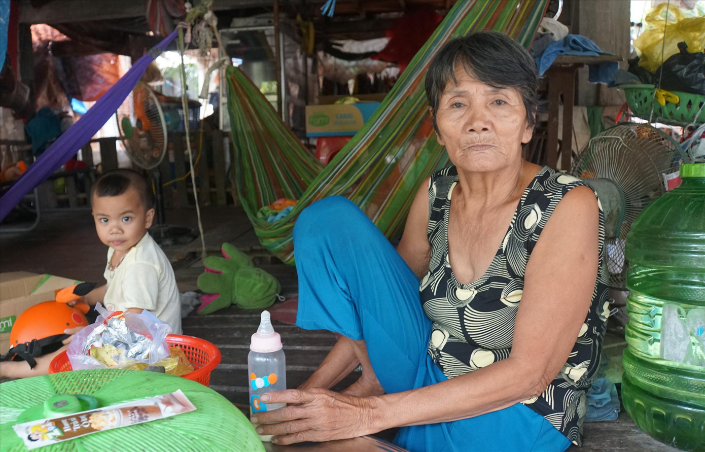 Bà Nguyễn Thị Huệ cùng cháu nội trong căn nhà tạm bợ ẢNH: HÒA HỘI
