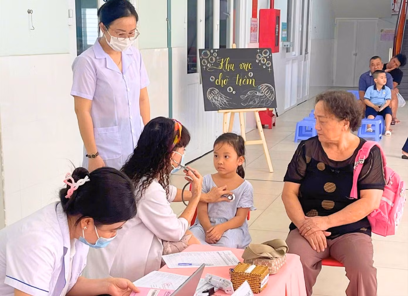 Bác sĩ khám sàng lọc sức khỏe cho học sinh ở quận 7, TPHCM trước khi tiêm vắc xin phòng bệnh sởi ảnh: Phú Khánh