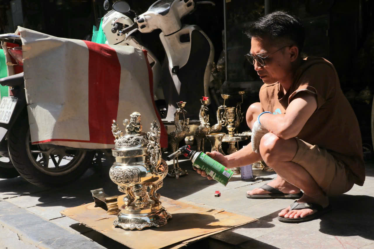 Ông Sơn đang sơn bóng đồ đồng