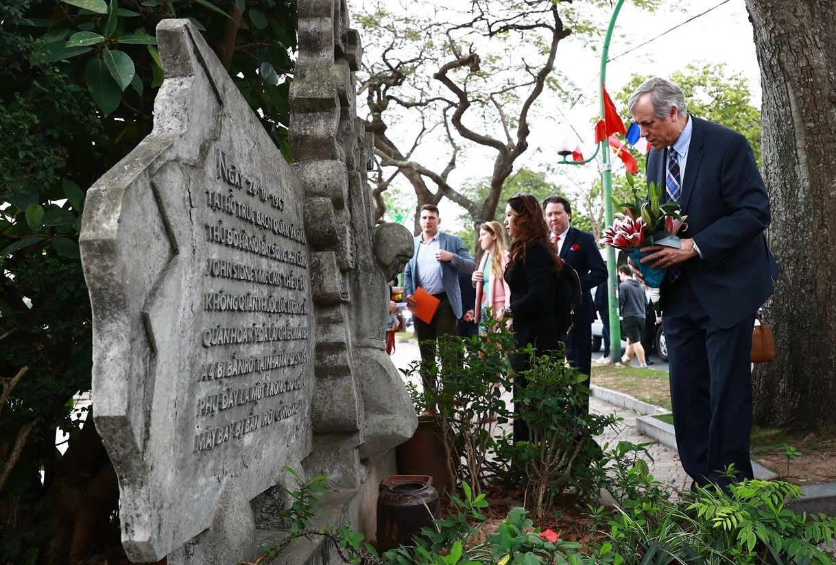 Thượng nghị sĩ Jeff Merkley, trưởng đoàn nghị sĩ Mỹ thăm Việt Nam tháng 4/2023, đặt hoa bên bức phù điêu bên hồ Trúc Bạch, Hà Nội Ảnh: ĐSQ Mỹ